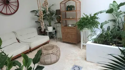 a living room with a couch and lots of plants at Casa Isabel aeropuerto feria Valencia in Partida de La Cañada