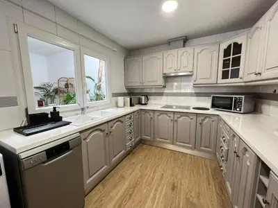 a kitchen with white cabinets and a sink and a window at Casa Isabel aeropuerto feria Valencia in Partida de La Cañada