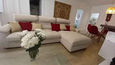 a living room with a white couch and a vase of flowers at Casa Isabel aeropuerto feria Valencia in Partida de La Cañada