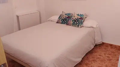a white bed with two pillows on top of it at Valencia Centro andando y Playa malvarrosa tranvía in Valencia