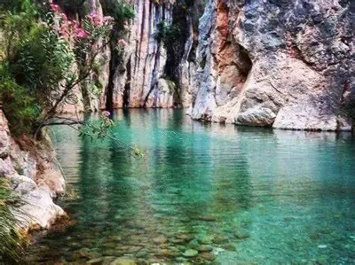 a river with green water and a rocky cliff at Apartamento Paco entre Valencia y Castellón in Benafer