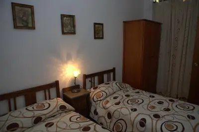 a bedroom with two beds and a lamp on a table at Apartamento Paco entre Valencia y Castellón in Benafer