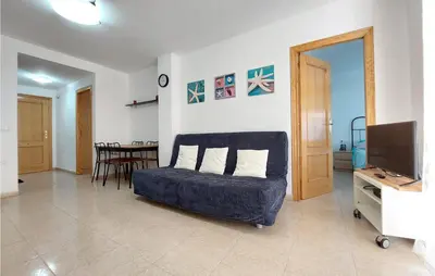 a living room with a couch and a television at Gorgeous Apartment In Playa De Moncofa in Moncófar