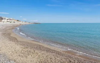 a beach with the ocean and buildings in the background at Gorgeous Apartment In Playa De Moncofa in Moncófar