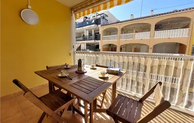 a wooden table and chairs on a balcony at Gorgeous Apartment In Playa De Moncofa in Moncófar