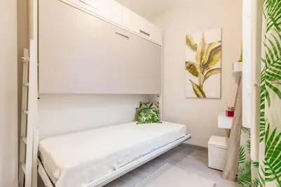 a small white bedroom with a bed in it at Gran Vía by District Key in Valencia
