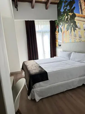 a bedroom with a large bed and a large window at Hotel BESTPRICE Valencia in Valencia