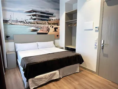 a bedroom with a bed with a painting of a harbor at Hotel BESTPRICE Valencia in Valencia