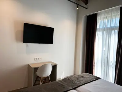 a bedroom with a bed and a desk with a television on the wall at Hotel BESTPRICE Valencia in Valencia