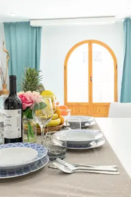 a table with plates and glasses and a bottle of wine at Grand Villa Valencia - 8 min to Center by Metro in Valencia