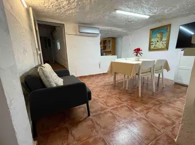 a living room with a table and a dining room at LA CUEVA de TONI EL SECO in Paterna
