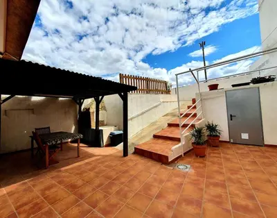 a patio with a bench and stairs on a house at LA CUEVA de TONI EL SECO in Paterna