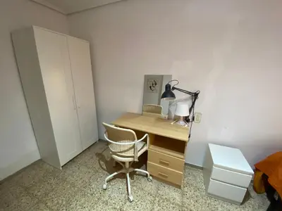 a bedroom with a desk with a chair and a lamp at FLAT FAMILY NEAR BEACH GARDEN CENTER AND METRO in Valencia