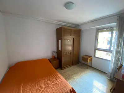 a bedroom with a bed and a dresser and a window at FLAT FAMILY NEAR BEACH GARDEN CENTER AND METRO in Valencia