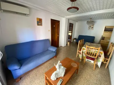 a living room with a blue couch and a table at FLAT FAMILY NEAR BEACH GARDEN CENTER AND METRO in Valencia