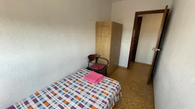a bedroom with a bed and a chair in a room at flat Holiday friend group or family near beach center blasco ibanez in Valencia