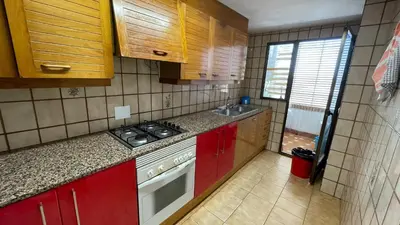 a small kitchen with red cabinets and a sink at flat Holiday friend group or family near beach center blasco ibanez in Valencia