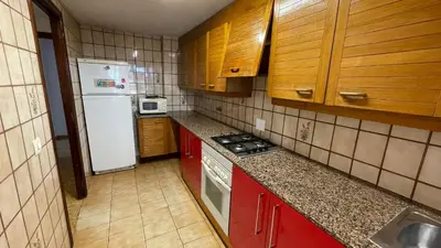 a kitchen with a white refrigerator and red cabinets at flat Holiday friend group or family near beach center blasco ibanez in Valencia