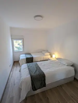 two beds in a room with white walls and wood floors at Entre montañas in Dos Aguas