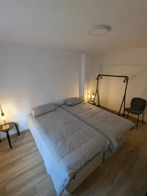 a bedroom with a large bed with two chairs and two lamps at Entre montañas in Dos Aguas