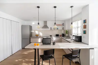 a kitchen with a table with a laptop on it at Espectacular piso reformado al lado del rio Turia in Valencia