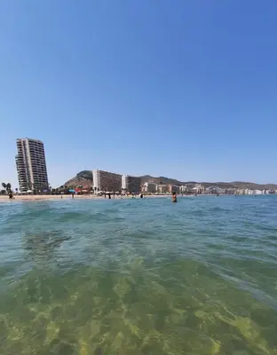 a body of water with a beach and buildings at Terraza con vistas al mar Parking privado 120 mts, junto a la playa in Cullera
