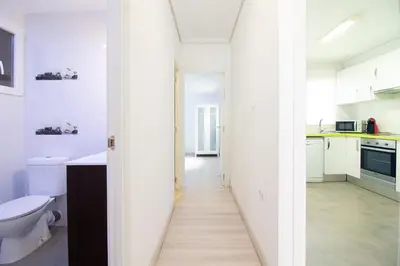 a white bathroom with a toilet and a sink at Global Vacacional, Apartamento de 4 habitaciones a 100 m de la playa in Puerto de Sagunto