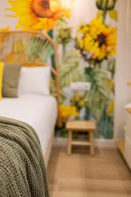 a bedroom with a bed and a table with flowers on the wall at FLORIT FLATS - The Green Apartments in Valencia