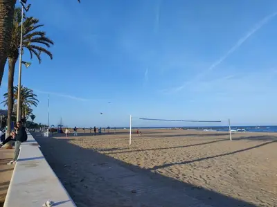 a man is flying a kite on the beach at Playa Puebla de Farnals Valencia in Masalfasar