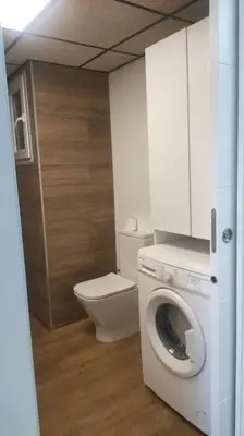 a bathroom with a toilet and a washing machine at Playa Puebla de Farnals Valencia in Masalfasar