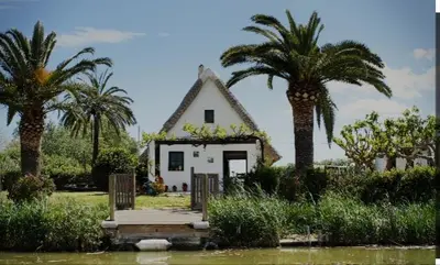 a small white house with palm trees in front of it at Loft B El Ramellet in Alginet