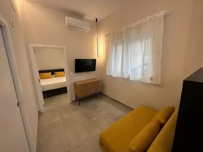 a living room with a yellow couch and a bed at Industrial Style Ruzafa in Valencia